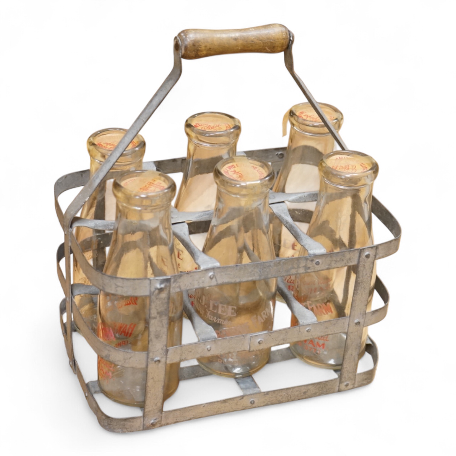 A vintage metal crate of six H J Lee, Horsham milk bottles